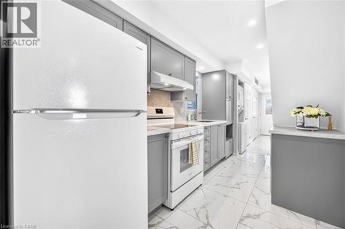 White appliances, gray cabinetry, light-toned backsplash, white marble-pattern flooring, and recessed ceiling lighting - 4 Albemarle Street, Hamilton, ON 