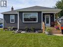 Dark gray horizontal siding exterior with white trim, dark shingle roof, and a wood front porch - 487 Scholfield Avenue N, Welland, ON 