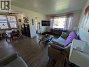 Wood-finish flooring throughout, living area with large window, and dining area featuring an angled ceiling with a ceiling fan - 487 Scholfield Avenue N, Welland, ON 