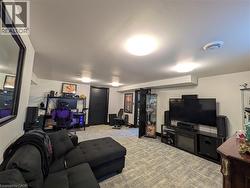 Recessed lighting, wood-finish flooring, and a built-in media console with an electric fireplace - 
