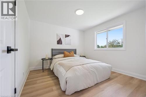 Bright room featuring light wood-finish flooring, white baseboards, and a contemporary flush-mount ceiling light - 299 Dale Crescent, Waterloo, ON 