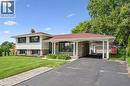 Split-level residence featuring brick and siding exterior, a prominent carport, dark-framed windows with shutters, and a red-toned roof - 299 Dale Crescent, Waterloo, ON 