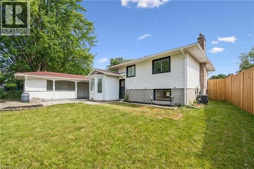 Rear exterior featuring white siding, a brick chimney, and a bay window - 299 Dale Crescent, Waterloo, ON 