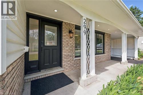 Covered front porch featuring brick facade, white siding, decorative white pillars, and a black entry door with leaded glass - 299 Dale Crescent, Waterloo, ON 