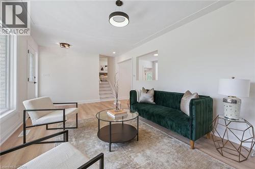 Living area featuring light wood-finish flooring, white walls, and a contemporary ceiling light fixture - 299 Dale Crescent, Waterloo, ON 