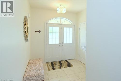Entryway featuring double doors with glass lites, an arched transom window, and tile flooring - 25 Guest Street, Hamilton, ON 