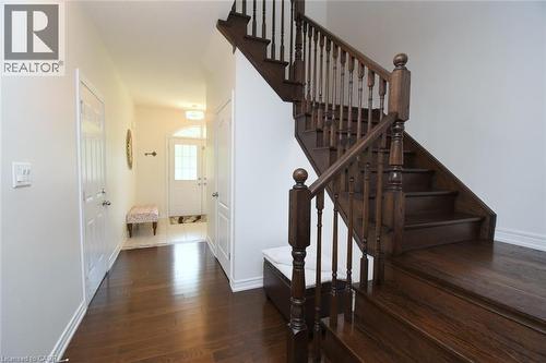 Hardwood flooring, wood staircase with dark balusters, white interior doors, arched transom window, recessed lighting - 25 Guest Street, Hamilton, ON 