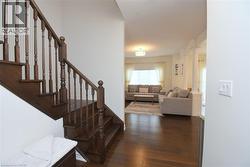 Hardwood staircase with turned balusters, rich wood-finish flooring, and recessed lighting - 