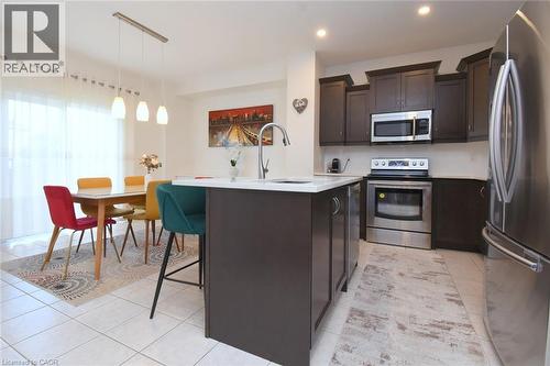 Kitchen featuring an island with a white countertop and dark cabinetry, stainless steel appliances, and recessed lighting - 25 Guest Street, Hamilton, ON 
