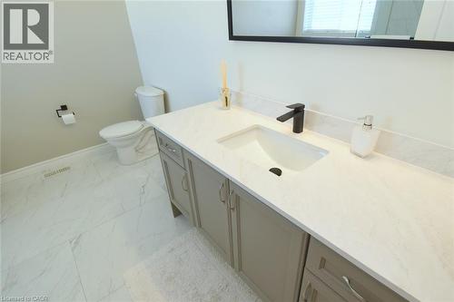 Vanity with white countertop, integrated sink, and matte black faucet - 25 Guest Street, Hamilton, ON 