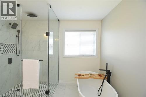 Freestanding soaking tub with a floor-mounted matte black faucet - 25 Guest Street, Hamilton, ON 