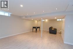 Recessed lighting, light wood-finish flooring, white trim, and a window - 