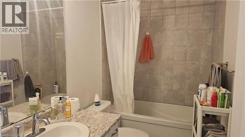 Bathtub with tile surround, vanity with single basin sink, and ample mirror - 3 Sharp Drive, Ancaster, ON 