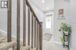 Foyer featuring light-toned tile flooring, recessed lighting, and a front entry door with transom window - 