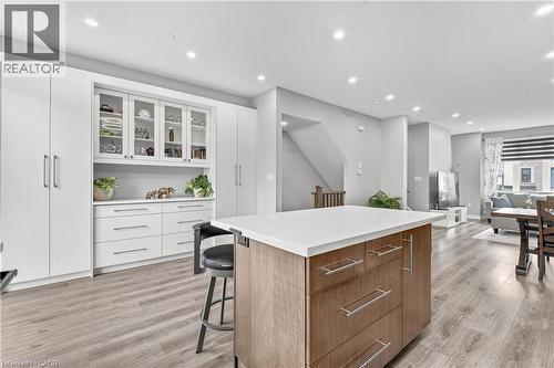 Open-concept kitchen with a central island and light-tone wood-finish flooring - 1890 Rymal Road E Unit# 144, Hamilton, ON 