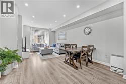 Recessed lighting, wood-finish flooring, light grey walls, and window treatments - 