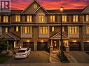 Brick and siding facade with dark shutters, individual garage, covered front entry, and exterior lighting - 1890 Rymal Road E Unit# 144, Hamilton, ON 