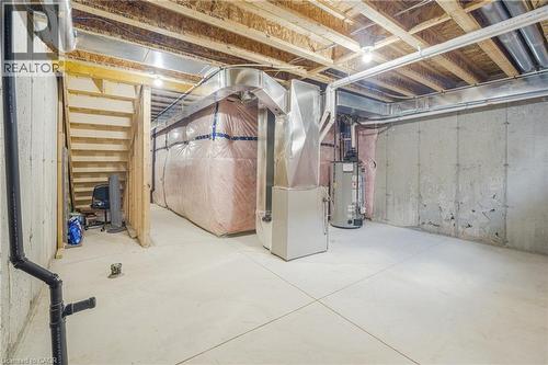 Unfinished basement with concrete flooring, exposed wood joists, and utility access - 1890 Rymal Road E Unit# 144, Hamilton, ON 