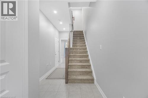 Tiled flooring, recessed ceiling lighting, carpeted stairs, and a wood-finish handrail - 1890 Rymal Road E Unit# 144, Hamilton, ON 
