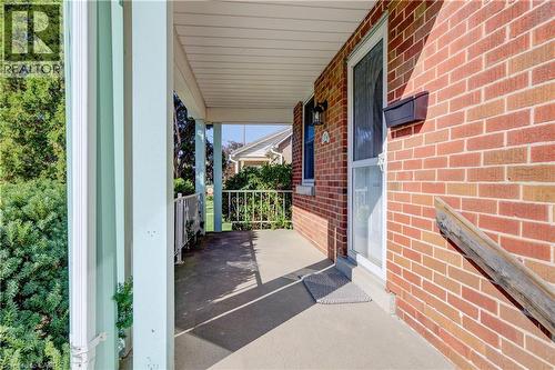 Brick exterior with covered porch, concrete flooring, and decorative metal railings - 174 Bridgeport Road E, Waterloo, ON 