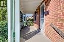 Brick exterior with covered porch, concrete flooring, and decorative metal railings - 174 Bridgeport Road E, Waterloo, ON 