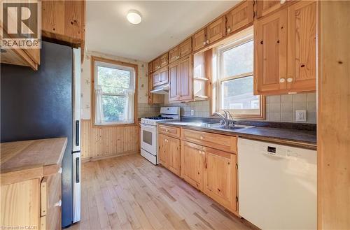 Wood-finish flooring, abundant wood cabinetry, tile backsplash, stainless steel sink - 174 Bridgeport Road E, Waterloo, ON 