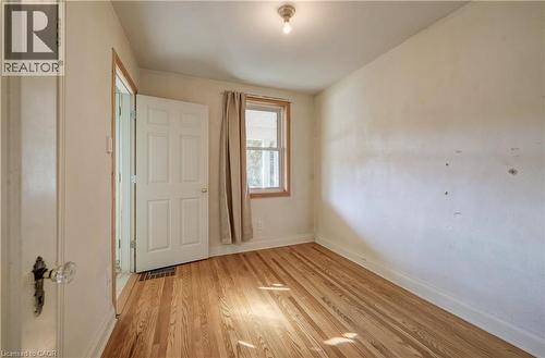 Hardwood flooring, natural light through window, ceiling-mounted light fixture, paneled door, bedroom on main level - 174 Bridgeport Road E, Waterloo, ON 