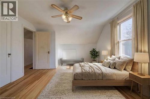 Wood-finish flooring with a ceiling fan light fixture primary bedroom virtual staged - 174 Bridgeport Road E, Waterloo, ON 