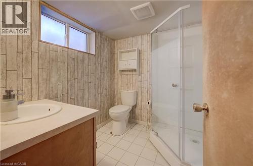 White tile flooring, wood-finish vanity, drop-in sink, corner shower enclosure - 174 Bridgeport Road E, Waterloo, ON 