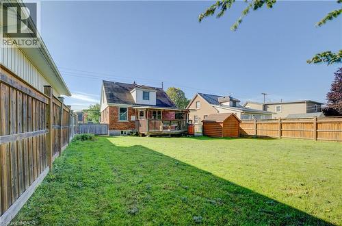 Expansive lawn with a wood privacy fence, featuring a wood deck and a wood shed - 174 Bridgeport Road E, Waterloo, ON 
