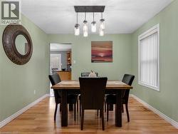 Wood-finish flooring with a modern linear chandelier featuring five glass pendants - 