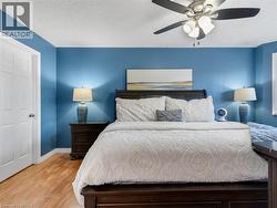 Wood-finish flooring with a ceiling fan and overhead lighting - 