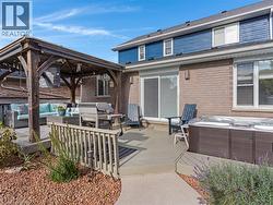 Expansive composite deck and patio space featuring a wood-frame pergola with integrated seating area, composite decking, and direct access to the brick home's rear elevation - 