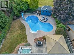 Freeform swimming pool with a concrete surround, an attached slide, and an adjacent spa - 