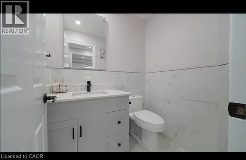 Vanity with stone countertop, integrated sink, and matte black faucet - 643 Doon South Drive, Kitchener, ON 