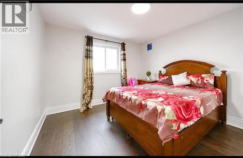 Wood-finish flooring, white painted walls, single window with roller shade, overhead dome light fixture, and crown molding - 643 Doon South Drive, Kitchener, ON 