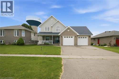 Two-story residence featuring a two-car garage, covered front porch, and dormer windows - 61 Sunnyside Drive, St. George, ON 