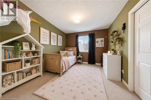 Built-in shelving unit with multiple compartments, wall-mounted floating shelves, and window with dark drapery - 61 Sunnyside Drive, St. George, ON 