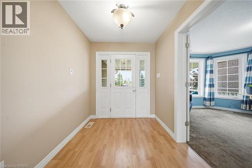 Entryway featuring wood-finish flooring and a white paneled door with glass inserts - 61 Sunnyside Drive, St. George, ON 