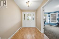 Entryway featuring wood-finish flooring and a white paneled door with glass inserts - 