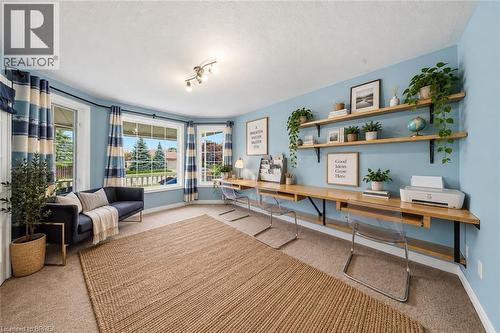 Bay windows, light blue walls, built-in wooden desk, open wooden shelving, and carpeted flooring - 61 Sunnyside Drive, St. George, ON 