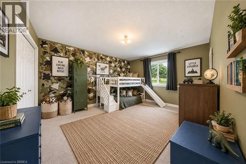 Carpeted flooring, window with natural light, ceiling-mounted light fixture, white interior door, and built-in wall shelving - 61 Sunnyside Drive, St. George, ON 