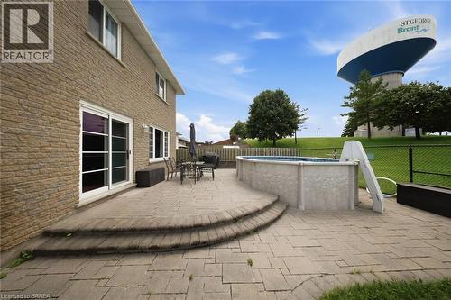 Brick exterior featuring multiple windows and a sliding glass door - 61 Sunnyside Drive, St. George, ON 