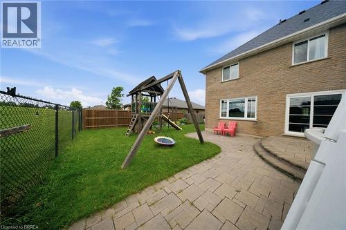 Rear exterior featuring a brick facade, multiple windows, and a sliding glass door - 61 Sunnyside Drive, St. George, ON 
