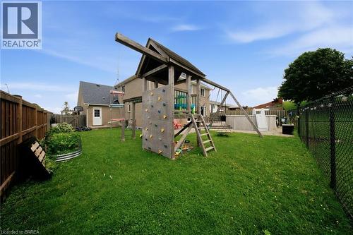 Expansive backyard featuring a manicured lawn, wood fencing, chain-link fencing, an above-ground pool, and a storage shed - 61 Sunnyside Drive, St. George, ON 