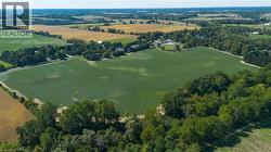 Expansive open fields surrounded by mature trees - 