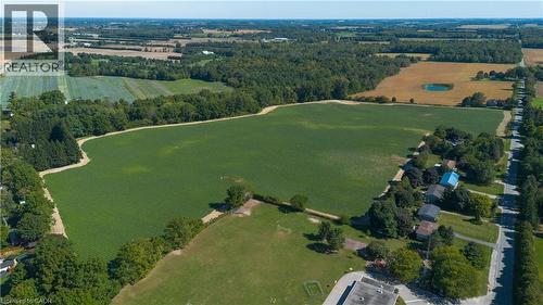 Expansive land parcel featuring open fields, surrounding mature trees, and nearby residential structures - 264 Old Highway 24, Waterford, ON 