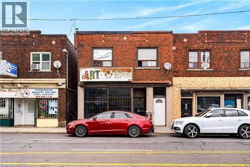 Brick facade featuring distinct window patterns and ground-level retail spaces - 689 E Barton Street E, Hamilton, ON 