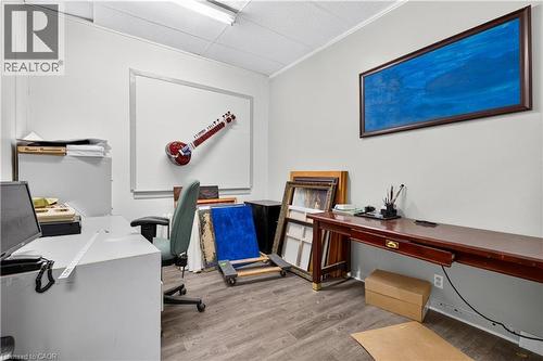 Wood-finish flooring, white walls, and a suspended acoustic tile ceiling - 689 E Barton Street E, Hamilton, ON 