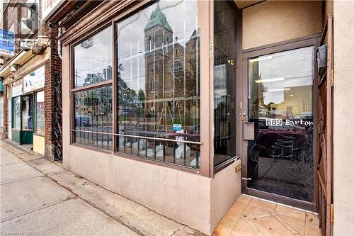 Commercial storefront with expansive display windows, street-level entrance, and tiled entry - 689 E Barton Street E, Hamilton, ON 